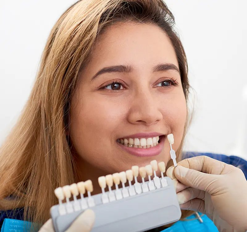 A patient has their dental shade taken in a dental office.