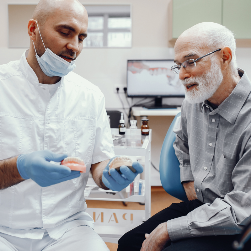 A denture patient happily working with a dentist who loves Russellville Dental Lab